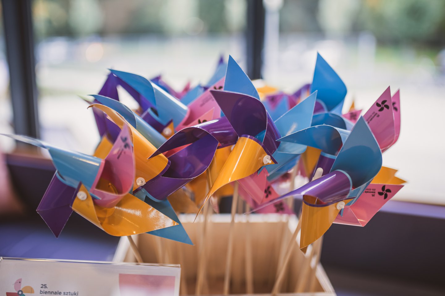 Kolorowe wiatraki wystające z drewnianego pudełka.