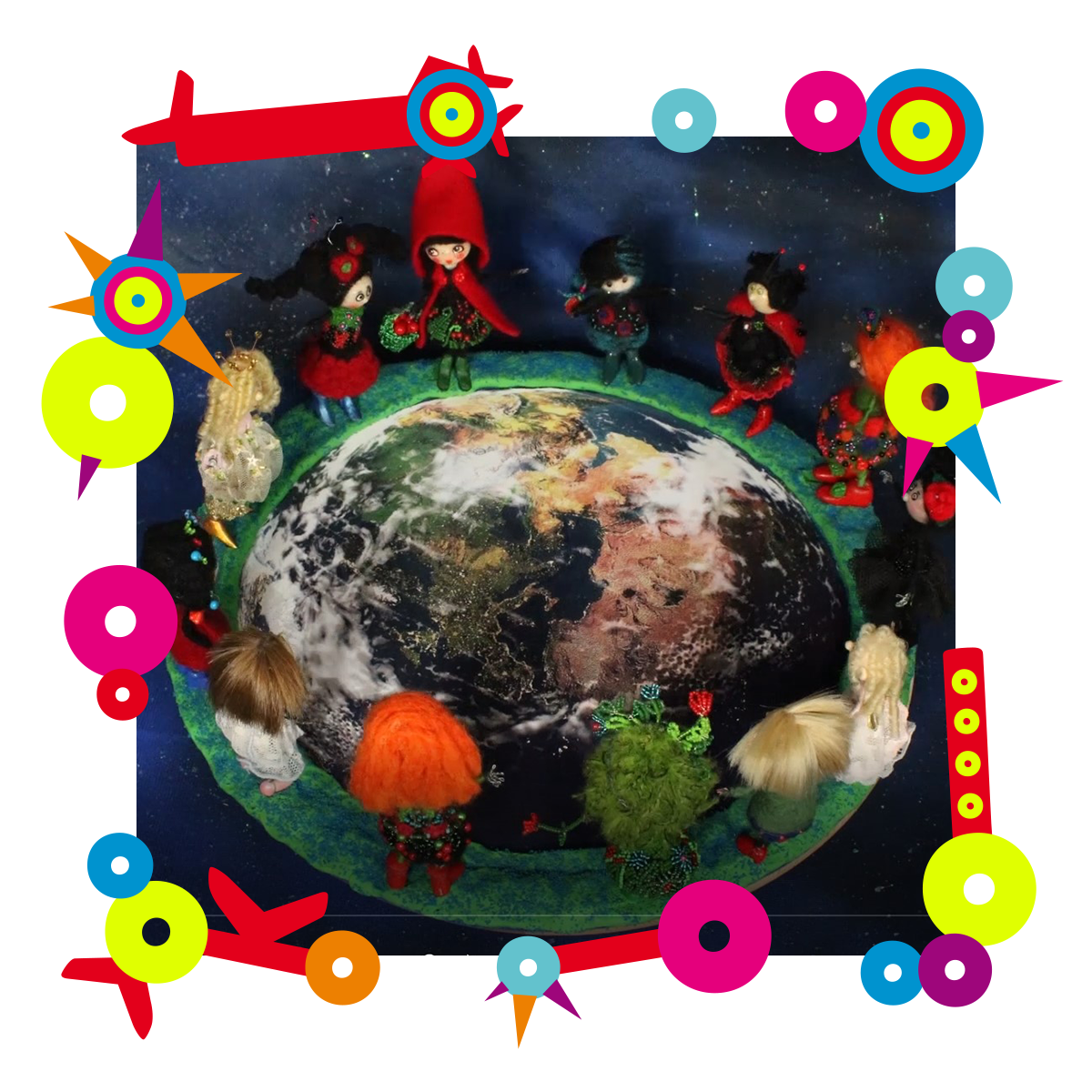Dookoła makiety Ziemi ułożone są laleczki w ludowych strojach. Zdjęcie znajduje się w kolorowej ramce.