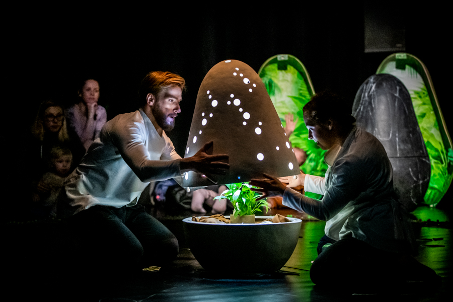 Na teatralnej scenie panuje półmrok. Jedyne światło pada z lamp umieszczonych w scenografii składającej się z jaj o wielkości kilkuletniego dziecka. Jedno z takich jaj zostaje otwarte przed kobietę i mężczyznę. W środku znajduje się roślina.